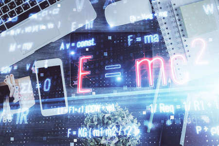 Double exposure of formula drawing over table with phone. Top view. Education concept.の写真素材