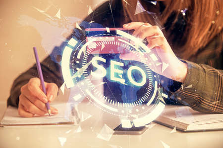 Double exposure of woman on-line shopping holding a credit card and SEO hologram drawing. Search...