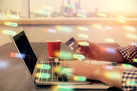 Double exposure of man hands holding a credit card and data theme drawing. E-commerce and technology concept.の写真素材