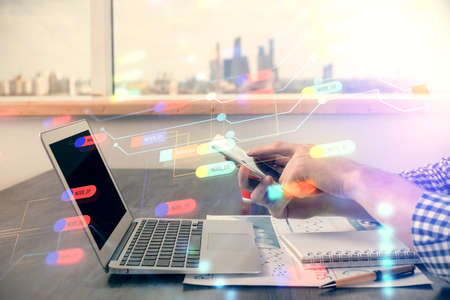 Double exposure of man's hand holding and using a digital device and data theme hologram drawing....