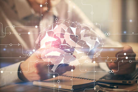 Double exposure of man's hand holding and using a digital device and brain hologram drawing. Data concept.の写真素材