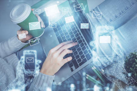 Double exposure of woman hands typing on computer and flying envelop drawing. E-Mail concept.