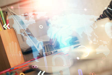 Double exposure of woman hands working on computer and world map hologram drawing. International...