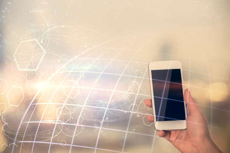 Double exposure of map sketch hologram and woman holding and using a mobile device.