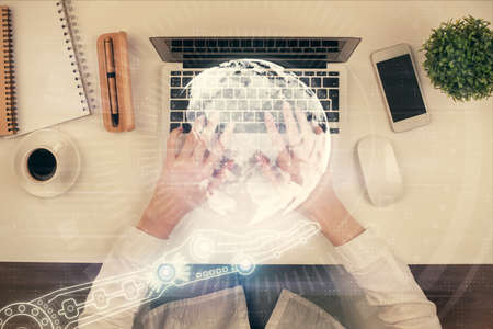Double exposure of woman hands working on computer and world map hologram drawing. Top View. International business concept.の写真素材