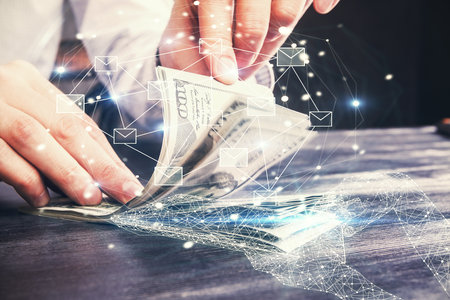Multi exposure of envelop drawing hologram and USA dollars bills and man hands. Technology concept.