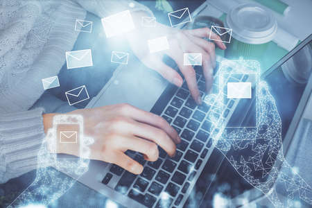 Double exposure of woman hands typing on computer and flying envelop drawing. E-Mail concept.