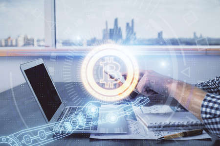 Double exposure of man's hands holding and using a phone and crypto currency blockchain theme...