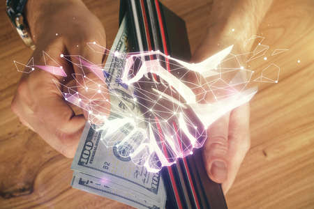 Multi exposure of handshake drawing hologram and USA dollars bills and man hands.