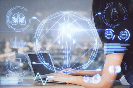 Double exposure of woman hands typing on computer and general theme hologram drawing. Education concept.の写真素材