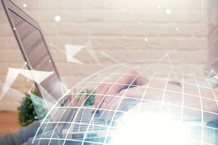 Double exposure of woman hands working on computer and world map hologram drawing. International...