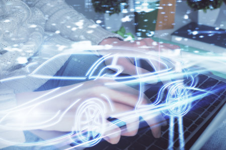 Double exposure of woman hands typing on computer and automobile theme drawing. High Tech concept.の写真素材