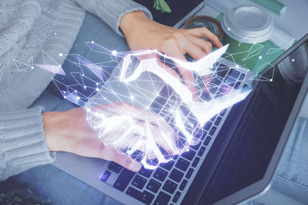 Double exposure of woman hands typing on computer and handshake drawing. Partnership concept.の写真素材