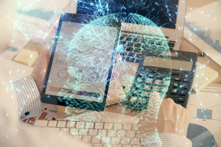 Double exposure of man's hand holding and using a digital device and brain hologram drawing. Data...