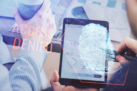 Double exposure of man's hands holding and using a digital device and fingerprint hologram drawing....