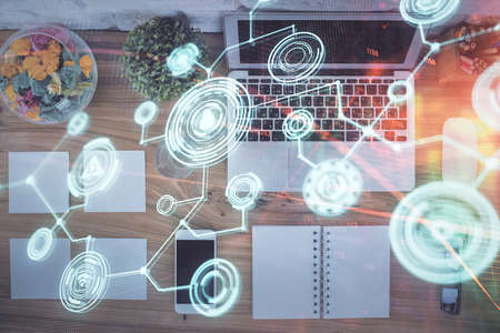 Social network hologram drawings over computer on the desktop background. Top view. Double exposure.