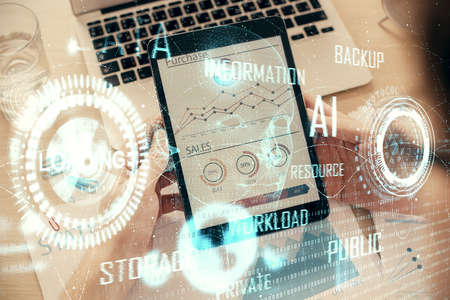 Double exposure of man's hand holding and using a digital device and data theme hologram drawing....