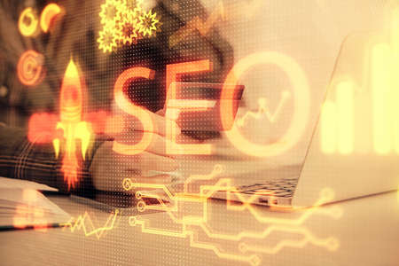 Double exposure of woman on-line shopping holding a credit card and SEO hologram drawing. Search...