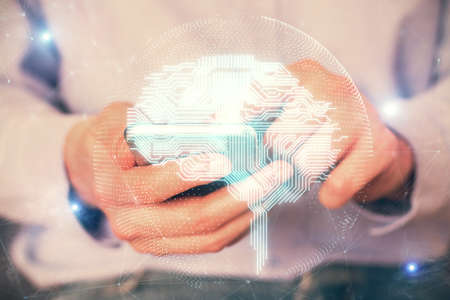 Double exposure of man's hand holding and using a digital device and brain hologram drawing. Data concept.の写真素材