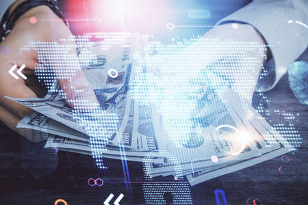 Double exposure of world map drawing hologram and us dollars bills and man hands.の写真素材