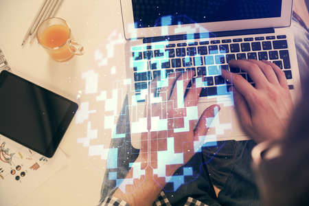 Multi exposure of man's hands typing over computer keyboard and data theme hologram drawing. Top view. Technology concept.の写真素材