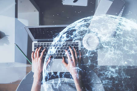 Double exposure of woman hands working on computer and social network theme hologram drawing. Top...