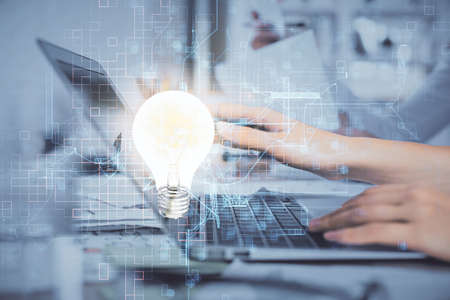 Double exposure of woman hands typing on computer and light bulb drawing. Idea concept.の写真素材