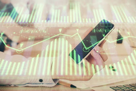 Double exposure of man's hand holding and using a digital device and data theme hologram drawing. Technology concept.の写真素材