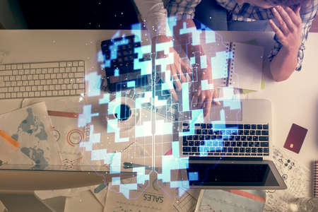 Double exposure of man and woman working together and data theme hologram drawing. Computer...
