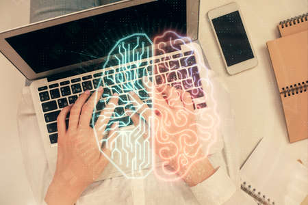 Double exposure of woman working on computer andhuman brain hologram drawing. Top View. Ai concept.