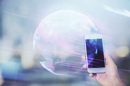 Double exposure of tech icon hologram and woman holding and using a mobile device. Technology concept.の写真素材