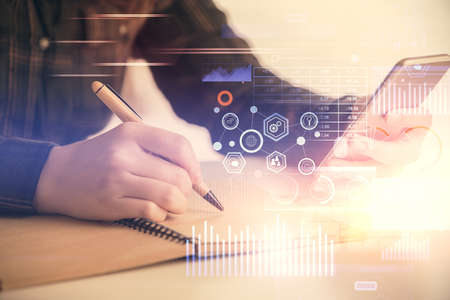 Double exposure of technology sketch hologram and woman holding and using a mobile device.の写真素材