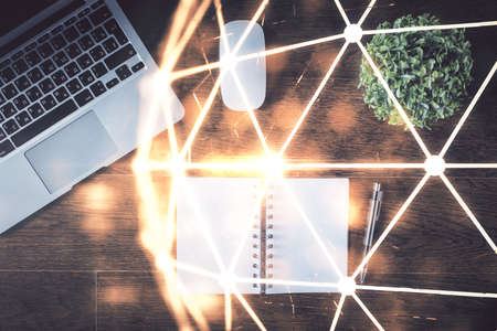 Social network hologram drawings over computer on the desktop background. Top view. Double exposure.