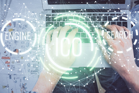Double exposure of man's hands typing over computer keyboard and crypto currency theme hologram drawing. Top view. Blockchain concept.の写真素材