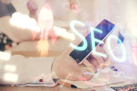 Multi exposure of man's hands holding and using a digital device and seo drawing. search...