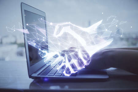 Double exposure of woman hands typing on computer and handshake drawing. Partnership concept.の写真素材