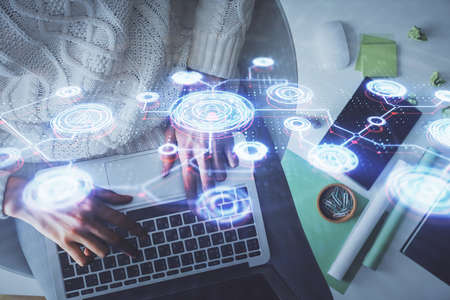 Double exposure of woman hands working on computer and social network theme hologram drawing. Top...
