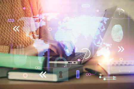 Double exposure of woman hands working on computer and world map hologram drawing. International...