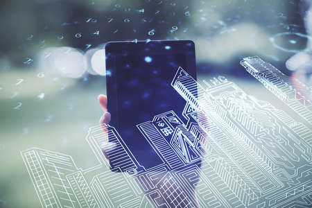 Double exposure of buildings hologram and woman holding and using a mobile device. Smart city...