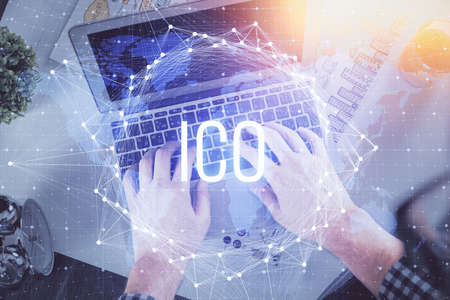 Double exposure of man's hands typing over computer keyboard and crypto currency theme hologram drawing. Top view. Blockchain concept.の写真素材