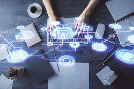 Double exposure of woman hands working on computer and social network theme hologram drawing. Top...