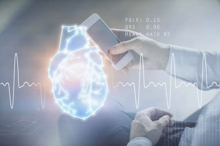 Double exposure of man's hands holding and using a phone and heart drawing. Medical education concept.の写真素材