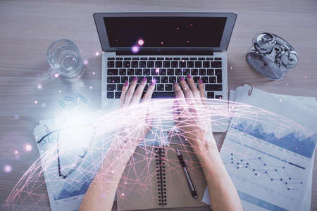 Double exposure of woman hands working on computer and social network theme hologram drawing. Top...