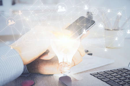 Double exposure of man's hands holding and using a phone and social network theme drawing.の写真素材