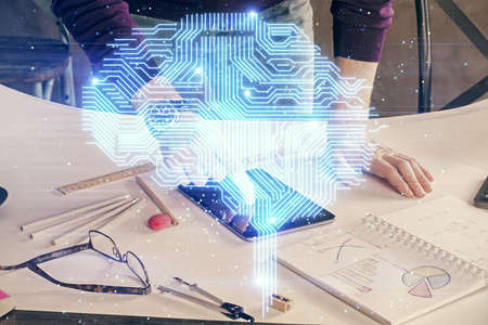 Double exposure of man's hand holding and using a digital device and brain hologram drawing. Data...