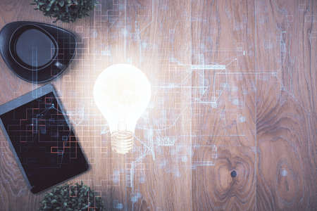 Double exposure of bulb drawing over table with phone. Top view. Concept of idea.の写真素材