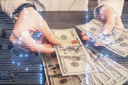Multi exposure of Tech drawing hologram and USA dollars bills and man hands. Technology concept.の写真素材