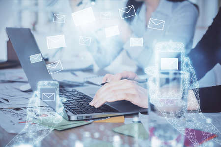 Double exposure of woman hands typing on computer and flying envelop drawing. E-Mail concept.