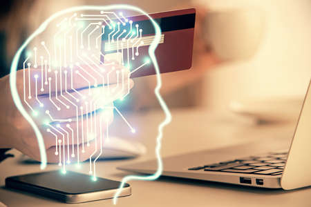 Double exposure of woman on-line shopping holding a credit card and brain hologram drawing. Data...