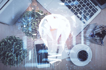 Double exposure of bulb drawing over table with phone. Top view. Concept of idea.の写真素材